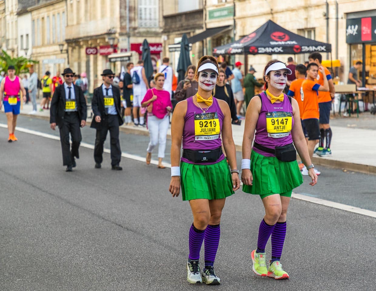 Vor dem Start des Marathon des Chateaux du Medoc gibt es das Defilee der Kostüme. Aus Lautsprechern schallen aus Filmen bekannte Ohrwürmer und die Stimmung unter den Teilnehmer ist bestens. Viele laufen in Gruppen oder als Paar / © Foto: Georg Berg