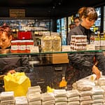 Im Maison du Beurre können Kunden dem Schlagen der Butter zuschauen.  Verkauft werden verschiedene auch aromatisierte Buttersorten / © Foto: Georg Berg