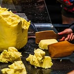 Die Butterstücke werden mit zwei Holzpaddeln geschlagen bis Wasser austritt. Die Butter beginnt zu weinen / © Foto: Georg Berg
