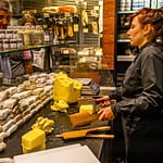 Verkaufstheke im Maison du Beurre von Jean Yves Bordier in Saint Malo. Eine Verkäuferin schlägt die Butter mit zwei Holzpaddeln / © Foto: Georg Berg