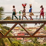 Frauen überqueren die alte Eisenbahnbrücke von Freetown, die Tengbeh-Brücke, und tragen dabei Waren auf dem Kopf / © Foto: Georg Berg