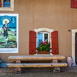 Absinth in Frankreich und der Schweiz. In Motiers im Schweizer Kanton Neuchâtel befindet sich das unterhaltsame Absinthmuseum, und an einigen Häuserwänden der Stadt erinnern historische Plakate an die Zeit der Prohibition / © Foto: Georg Berg