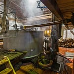 Aus dem Läuterbottich fließt die Zoigl-Würze in eine in den Boden eingelassene Wanne, aus der sie in die Sudpfanne hochgepumpt wird / © Foto: Georg Berg