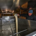 Hausbrauer Wolfgang Üblacker füllt zuerst flüssige Hefe in den Tank, damit sie sich gut mit der Bier-Würze mischt / © Foto: Georg Berg