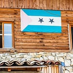 Die Flagge von São Tomé & Príncipe hängt am Gebäude der Schokoladenfabrik Frigoulette. Der Inselstaat im Golf von Guinea trägt auch den Namen Schokoladeninsel. 1822 ließen sich portugiesischen Siedler aus Brasilien auf São Tomé & Principe nieder. Sie brachten auch Kakaopflanzen mit.  Der Boden vulkanischen Ursprungs und die günstigen klimatischen Bedingungen ermöglichten eine rasche Entwicklung des Kakaoanbaus, der 1913 mit 36.000 Tonnen seinen Höhepunkt erreichte. Heute produziert die Insel nur rund 3.000 Tonnen und eine umweltfreundliche und nachhaltige Steigerung der Produktivität ist Firmengründer Bernard Xueref ein wichtiges Anliegen / © Foto: Georg Berg