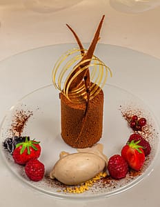 Die wunderschönen Desserts wie dieser Schockokuchen mit Timut Pfeffer an Tonka Eis werden von Florent Jestin dekoriert / © Foto: Georg Berg