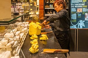 Im Maison du Beurre in Saint Malo teilt die Verkäuferin aus einem Butterblock Stücke von 125 g ab / © Foto: Georg Berg