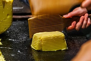 Im Maison de Beurre von Jean-Yves Bordier in Saint Malo schlagen Butter-Paddel Wasser aus der Butter heraus / © Foto: Georg Berg