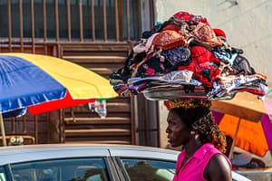 Frau trägt ein Tablett voller BHs auf dem Kopf / © Foto: Georg Berg