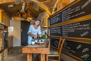 Gabriella in der Küche. Geradezu galaktisch schweben große Töpfe und Pfannen am Kellerfirmament / © Foto: Georg Berg