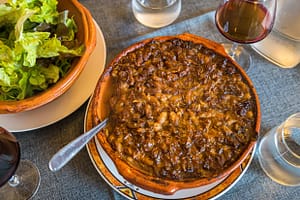 Chef Eric Rousselot bereitet das berühmte Cassoulet Imperial in der Hostellerie Etienne zu, die seit 1956 als Familienbetrieb geführt wird. Die braune Kruste gehört zu einem guten Cassoulet. Des weiteren nur noch ein einfacher Salat und ein Glas Wein - c’est tout - c’est bien! / © Foto: Georg Berg
