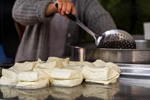 Nach rund 30 Minuten werden die Käsestücke aus dem heißen Wasser geholt und im Anschluss mit Salz und frischer Minze gewürzt / © Foto: Georg Berg