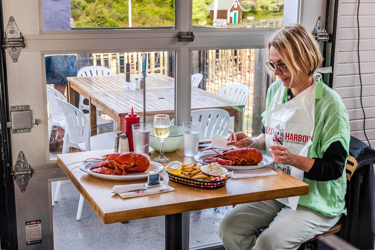 Frau isst Hummer mit Pommes und Cole Slaw am West Halls Harbour Road, Halls Harbour, Canada
