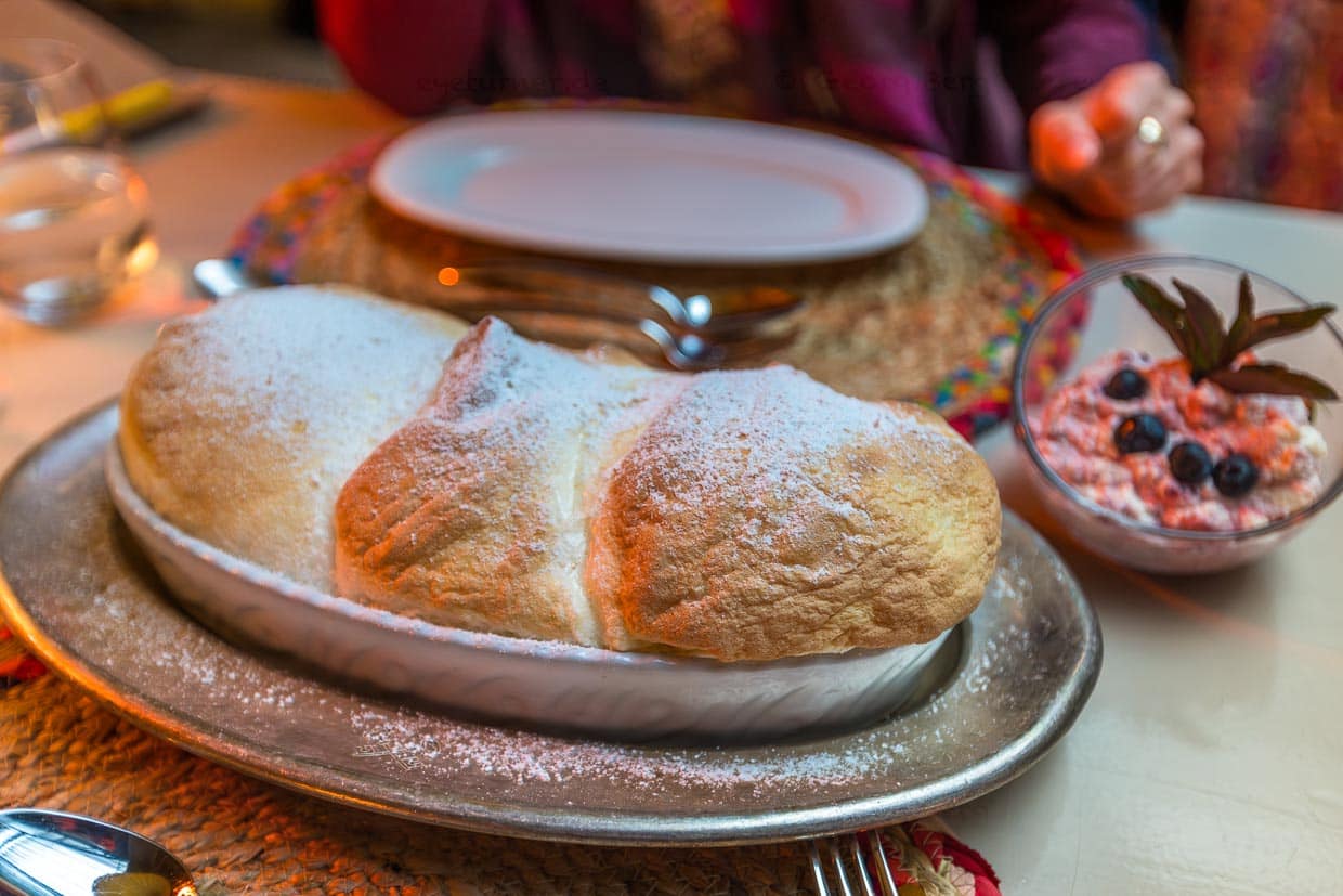 Salzburger Nockerln mit Preiselbeersahne und Puderzucker. Die drei Nocken repräsentieren die drei Salzburger Stadtberge: Kapuzinerberg, Mönchsberg und Rainberg. Salzburger Nockerln werden stets frisch zubereitet und sind ein Soufflé aus Eischnee, Zucker und Eigelb / © Foto: Georg Berg