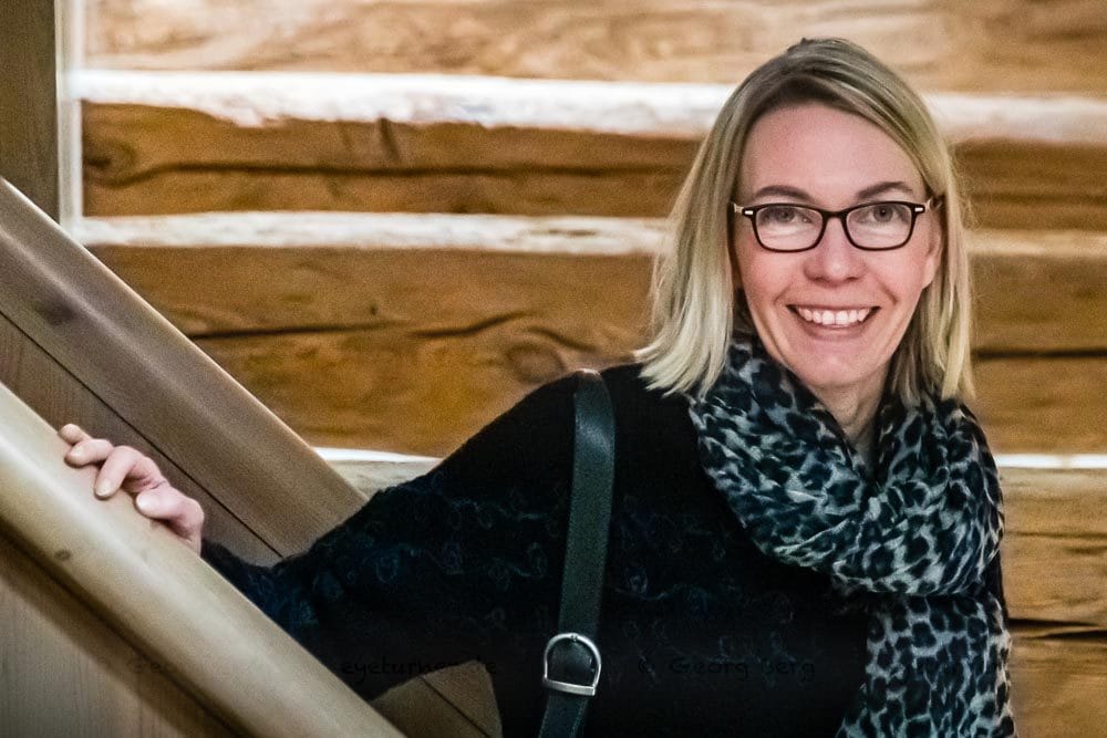 Angela Berg mitten im Gebälk. In vielen Räumen sind die alten Holzbalken offengelegt, werden in Kontrast zu modernen Möbeln gesetzt / © Foto: Georg Berg