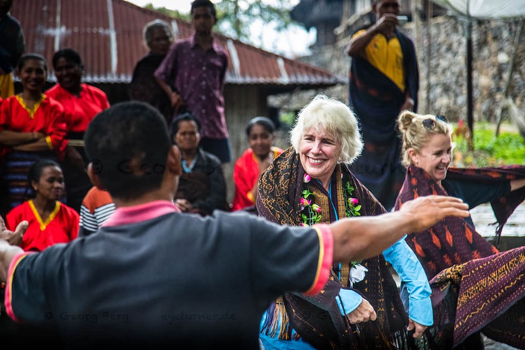 Indonesische Menschen in traditioneller Kleidung treffen sich mit Touristen / © Foto: Georg Berg