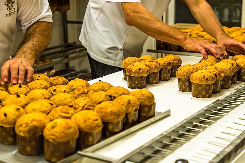 Die kleinen voran! Mini-Panettone verlassen als erstes den Backofen und werden zum Abkühlen auf ein Gestell gespießt / © Foto: Georg Berg