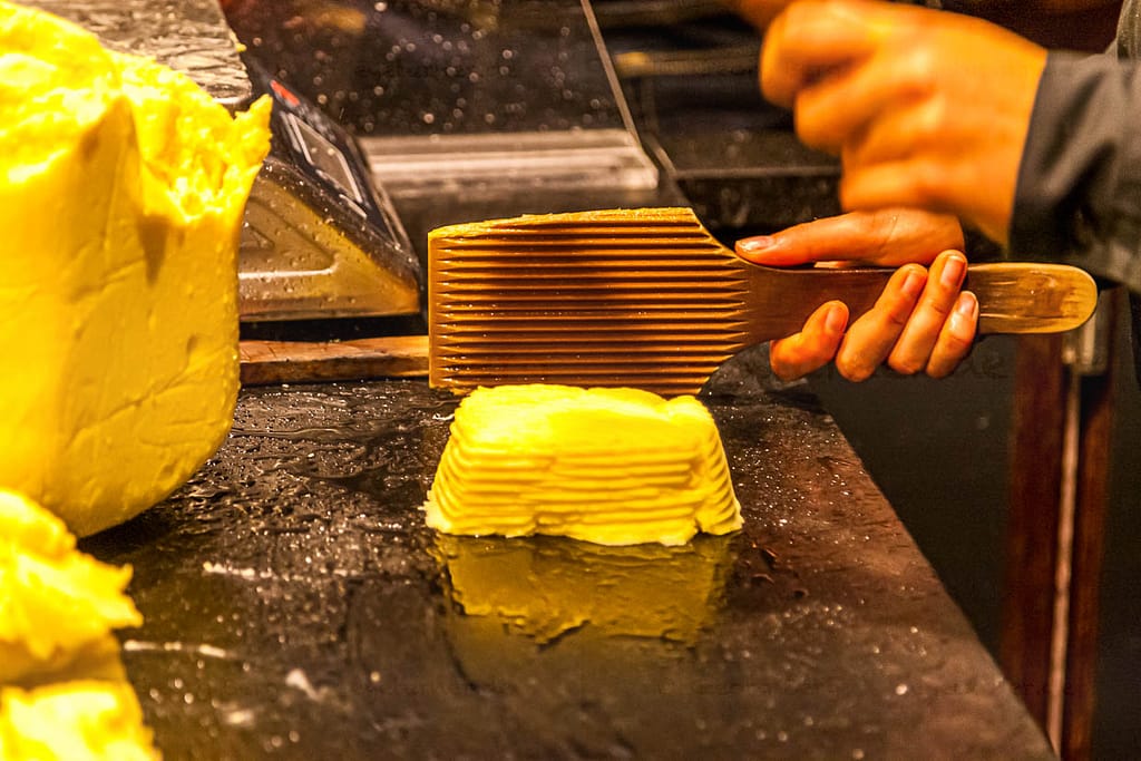 Im Maison de Beurre von Jean-Yves Bordier in Saint Malo schlagen Butter-Paddel Wasser aus der Butter heraus / © Foto: Georg Berg