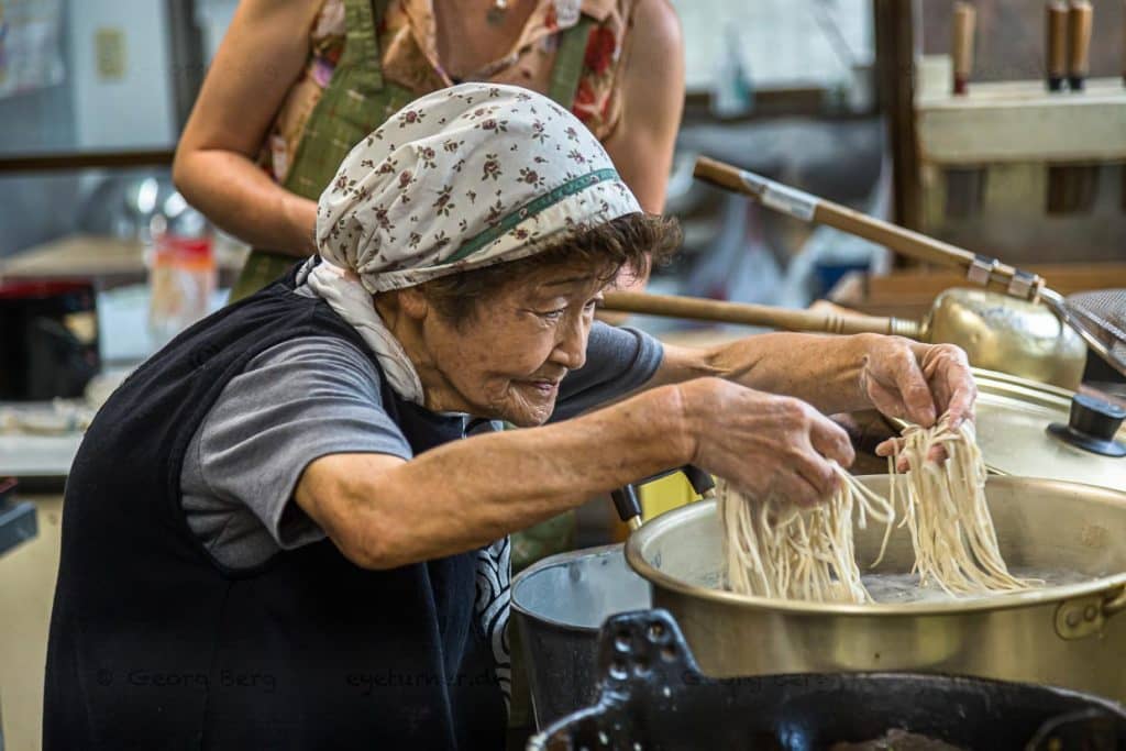 Buchweizennudel Produktion. Mit gespreizten Fingern fährt Sumiko Sano durch die dünnen Soba Nudeln. Sie sollen auf keinen Fall kleben / © Foto: Georg Berg