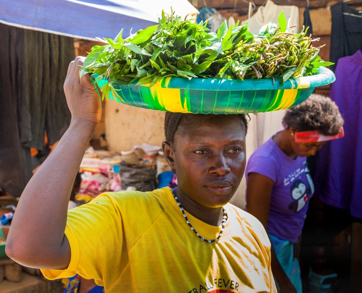 In Sierra Leone sind auch die Blätter der Kartoffel ein wichtiges Nahrungsmittel. Diese Frau bringt ihren Einkauf heim / © Foto: Georg Berg