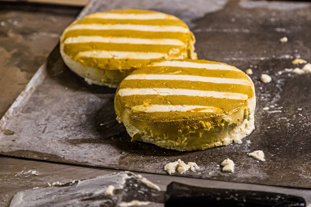 After 20 seconds in the dense smoke of straw, the cheese wheels are streaked / © Photo: Georg Berg