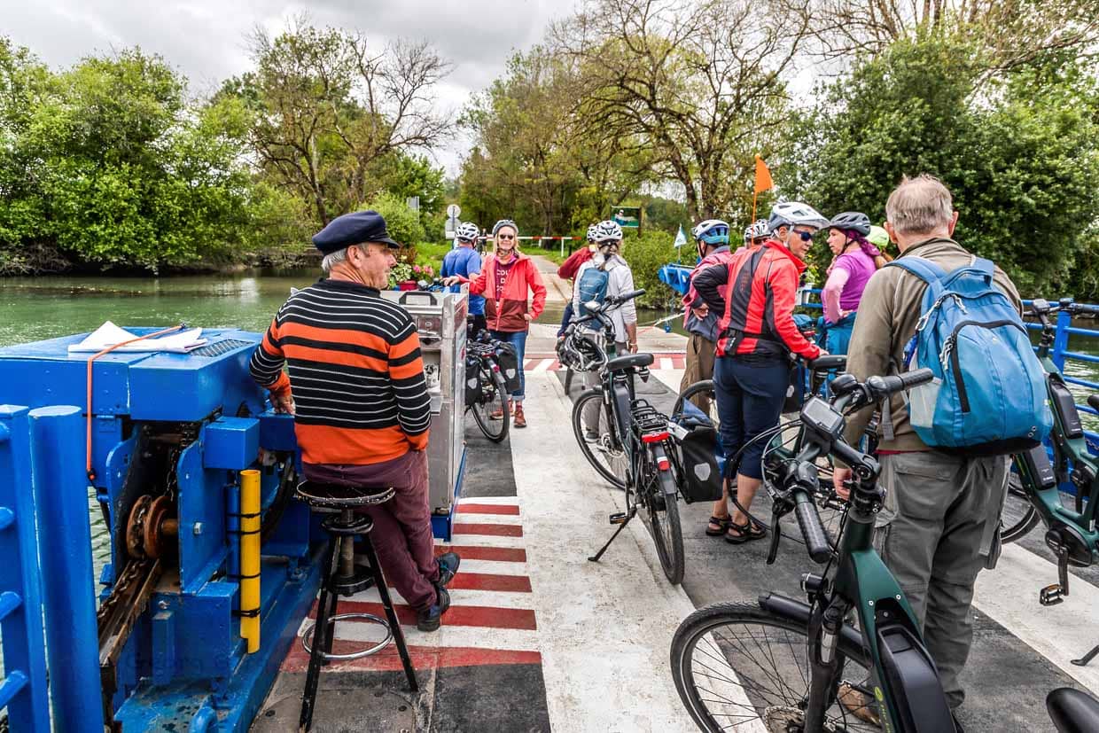A group of cyclists crosses the Charente by ferry / © Photo: Georg Berg