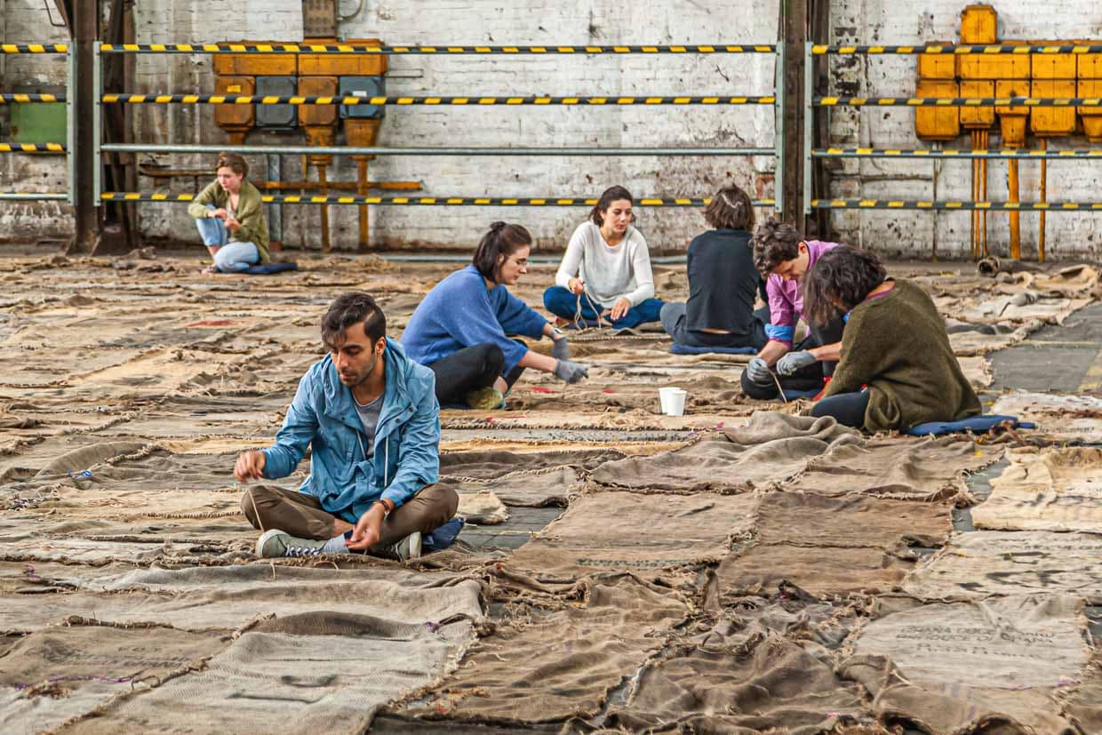 Performance: Studenten nähen die vielen Jutesäcke aneinander. Die gleiche Aktion fand auch in Athen statt / © Foto: Georg Berg