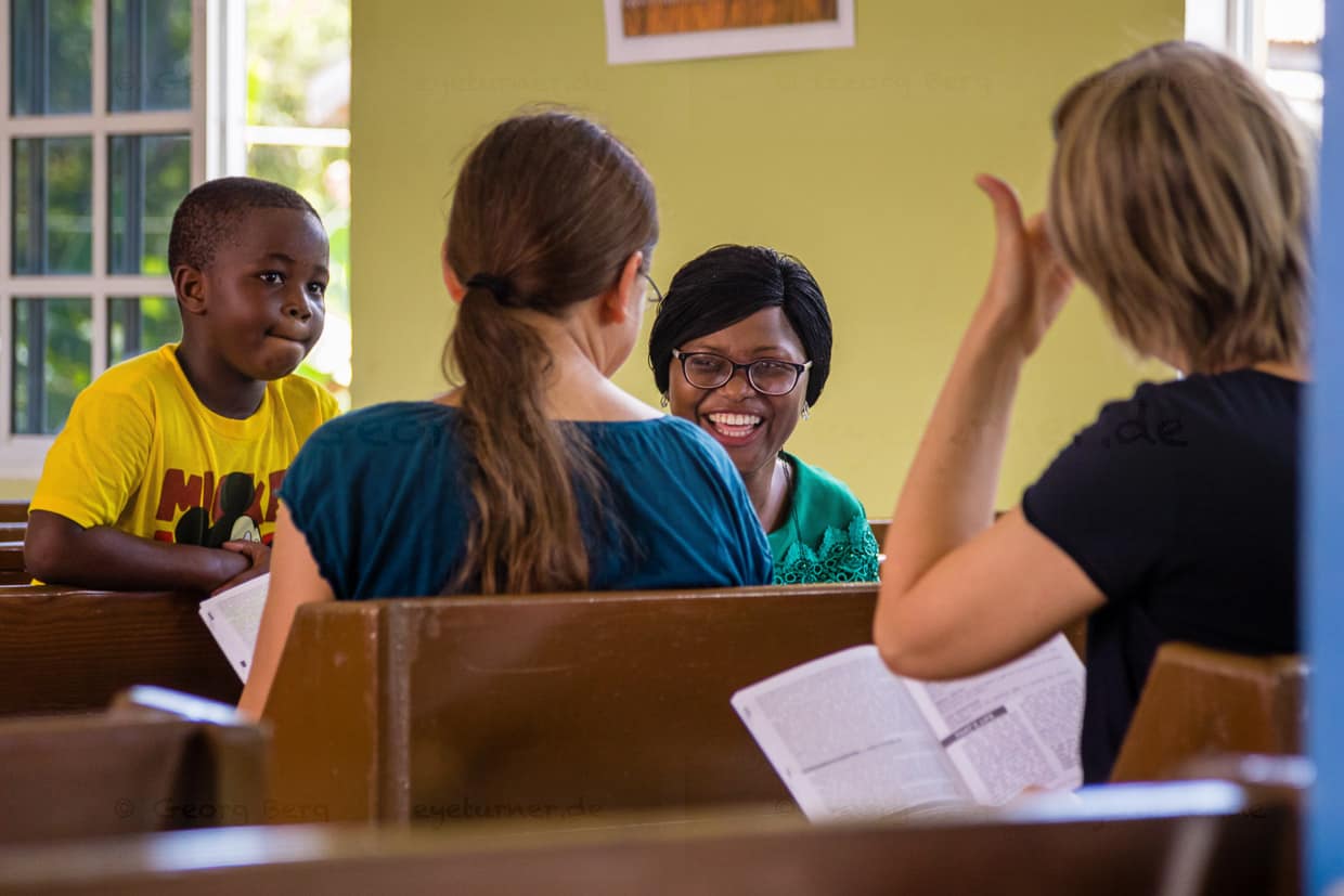Gedankenaustausch vor einem Baptistengottestdienst in the Lime auf Grenada. Im religiösen Gespräch vor dem Gottesdienst werden moralische Aspekte des Alltags diskutiert. Im Unterschied zu einer Predigt oder dem „Wort zum Sonntag“, kann sich jeder auf Augenhöhe einbringen / © Foto: Georg Berg