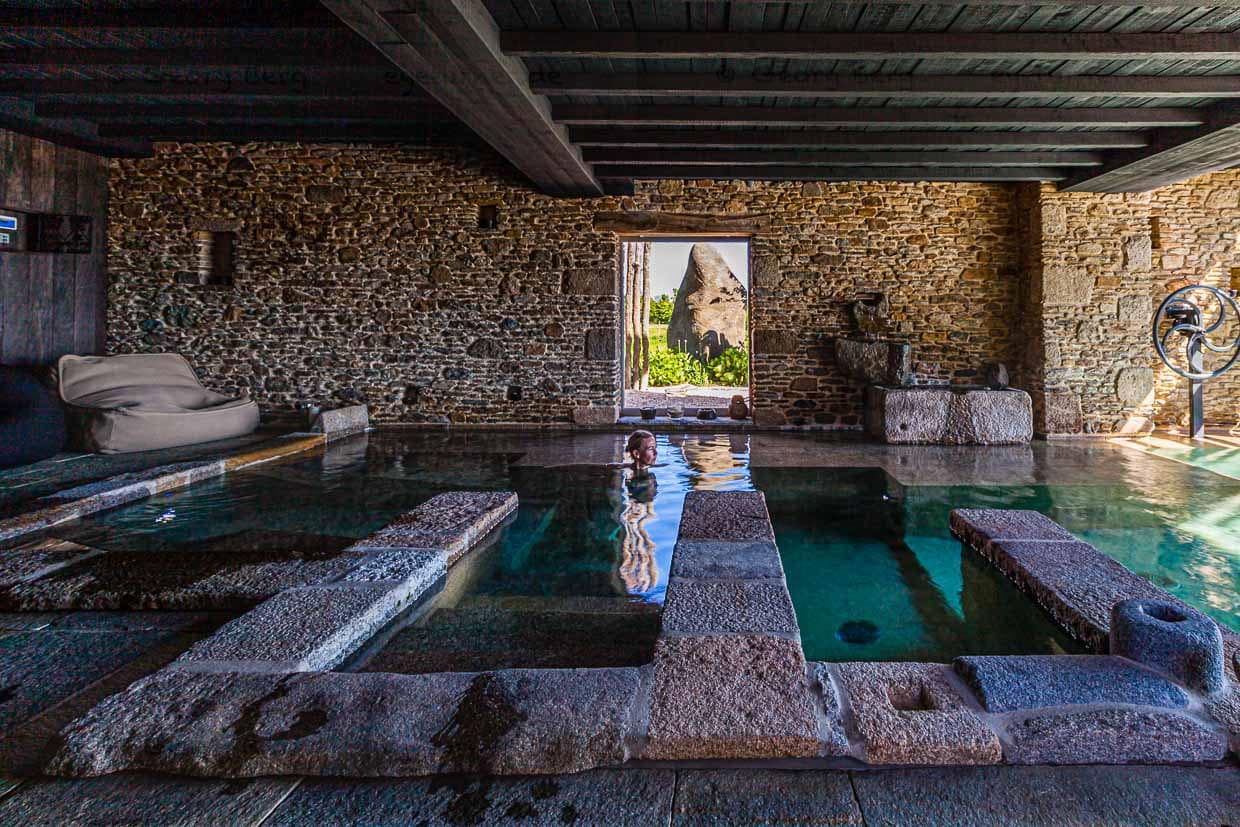 Ein riesiger Hinkelstein draußen vor dem Fenster und drinnen die sanfte Rauheit der steinernen Oberflächen im warmen Wasser / © Foto: Georg Berg