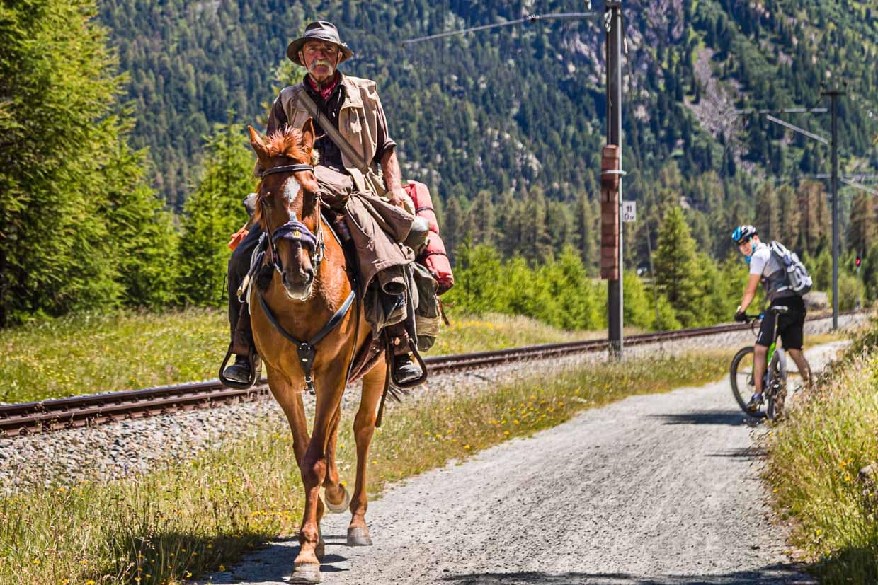 Da staunt der Hoteldirektor auf dem E-Bike. Einen Reisenden, der hoch zu Ross Graubünden durchquert, sieht auch er nicht alle Tage / © Foto: Georg Berg