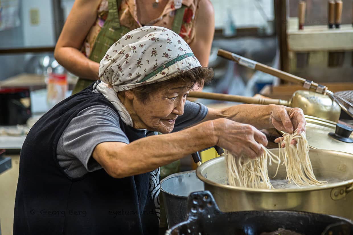 Buchweizennudel Produktion. Mit gespreizten Fingern fährt Sumiko Sano durch die dünnen Soba Nudeln. Sie sollen auf keinen Fall kleben / © Foto: Georg Berg