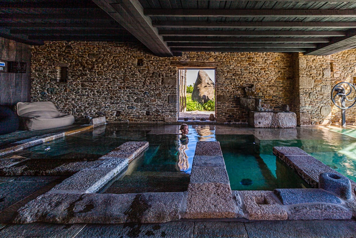 Ein riesiger Hinkelstein draußen vor dem Fenster und drinnen die sanfte Rauheit der steinernen Oberflächen im warmen Wasser / © Foto: Georg Berg