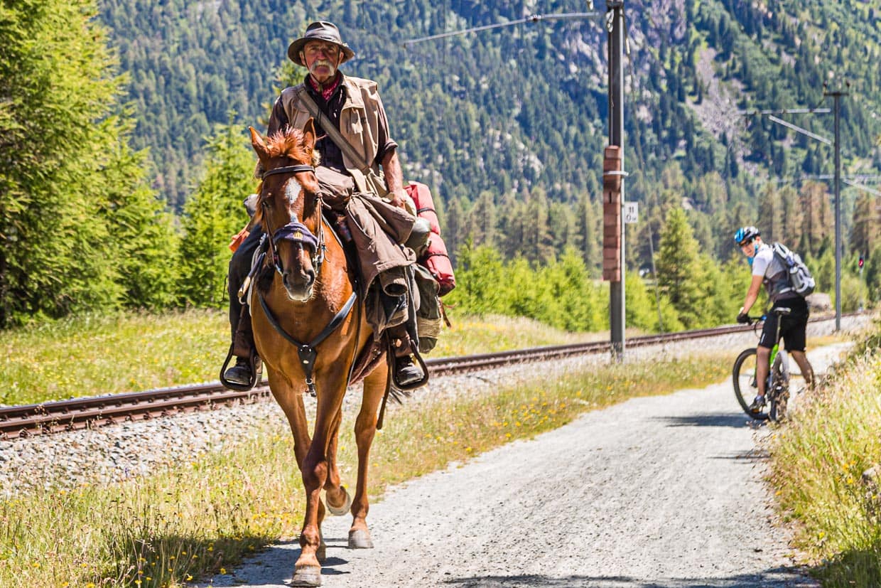 Da staunt der Hoteldirektor auf dem E-Bike. Einen Reisenden, der hoch zu Ross Graubünden durchquert, sieht auch er nicht alle Tage / © Foto: Georg Berg