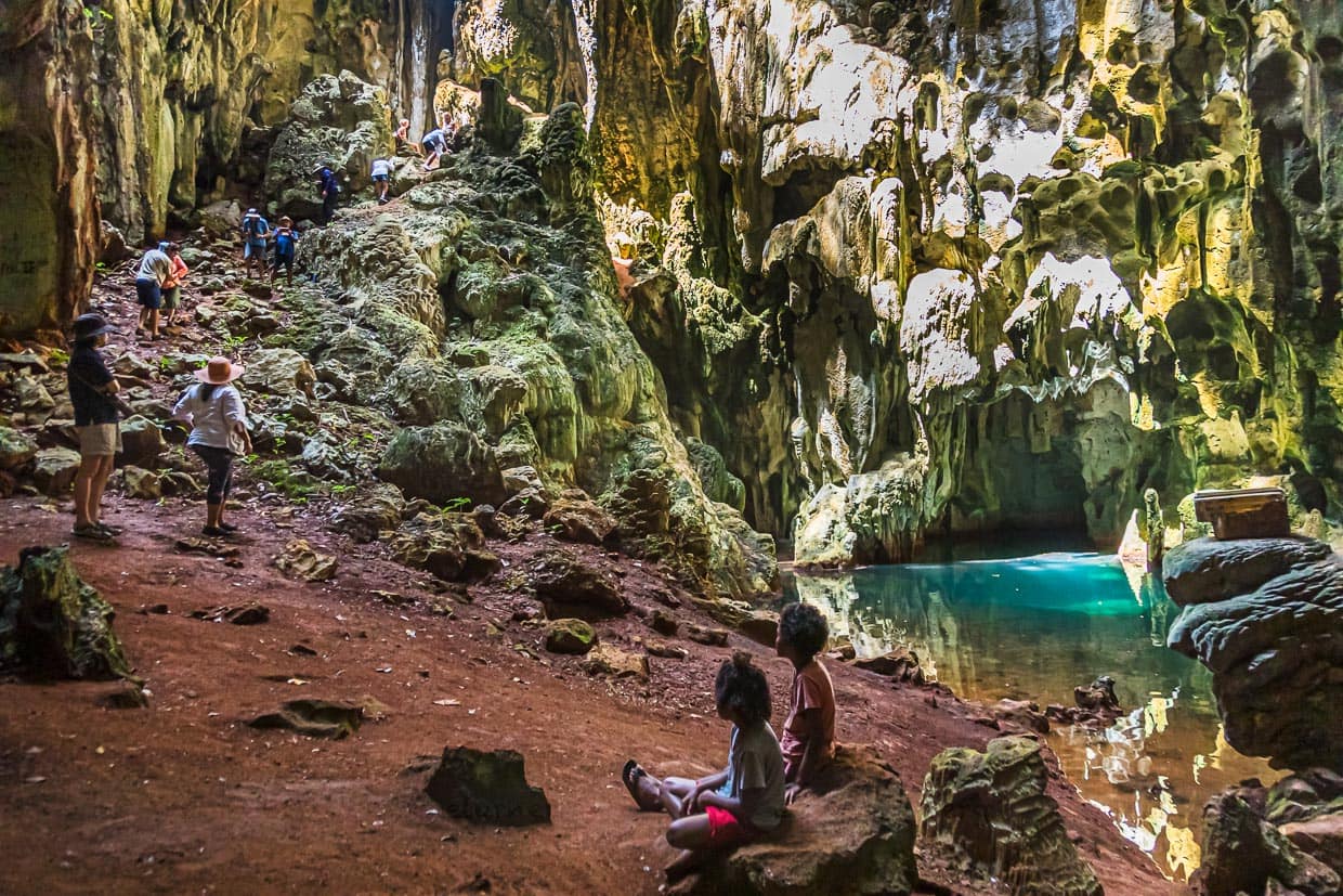 Einheimische in einer Brackwasserhöhle auf der Panasia Insel. Vorsichtig tastet sich die Reisegruppe bis zum Grund der natürlichen Kaverne / © Foto: Georg Berg