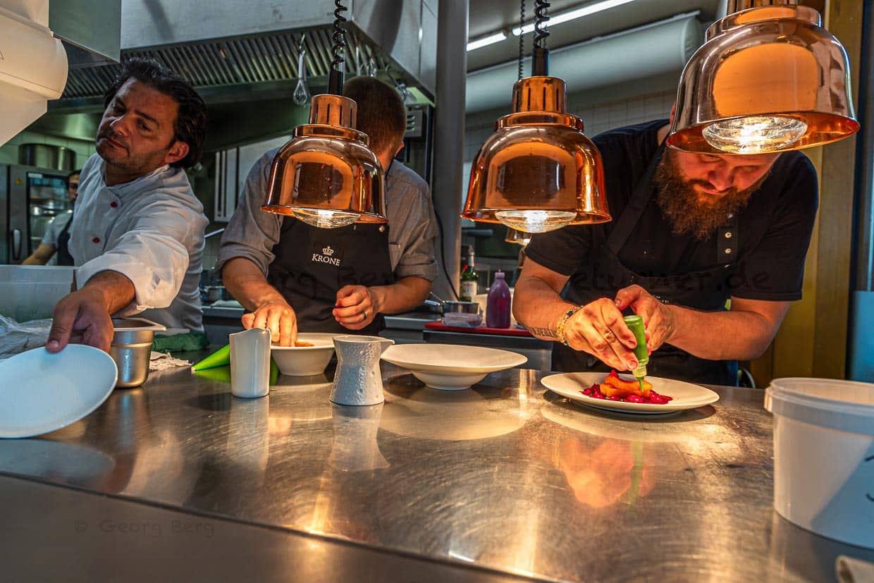 Peter Prüfer mit Team am Pass der Sommerküche, die die Gäste auf der Terrasse versorgt / © Foto: Georg Berg