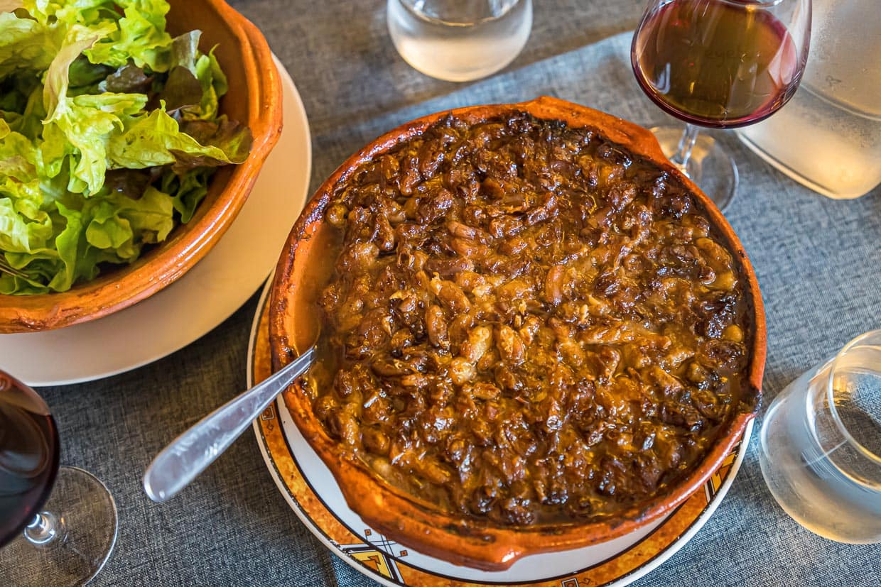 Chef Eric Rousselot bereitet das berühmte Cassoulet Imperial in der Hostellerie Etienne zu, die seit 1956 als Familienbetrieb geführt wird. Die braune Kruste gehört zu einem guten Cassoulet. Des weiteren nur noch ein einfacher Salat und ein Glas Wein - c’est tout - c’est bien! / © Foto: Georg Berg