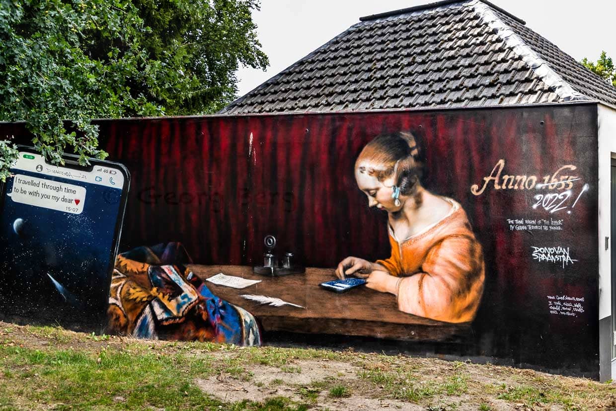 Wandbild "Reise durch die Zeit - Anno 1655 - 2022" von Donovan Spaanstra nach dem Vorblid der Briefschreiberin von Gerard ter Borch dem Jüngeren in Zwolle, Niederlande / © Foto: Georg Berg