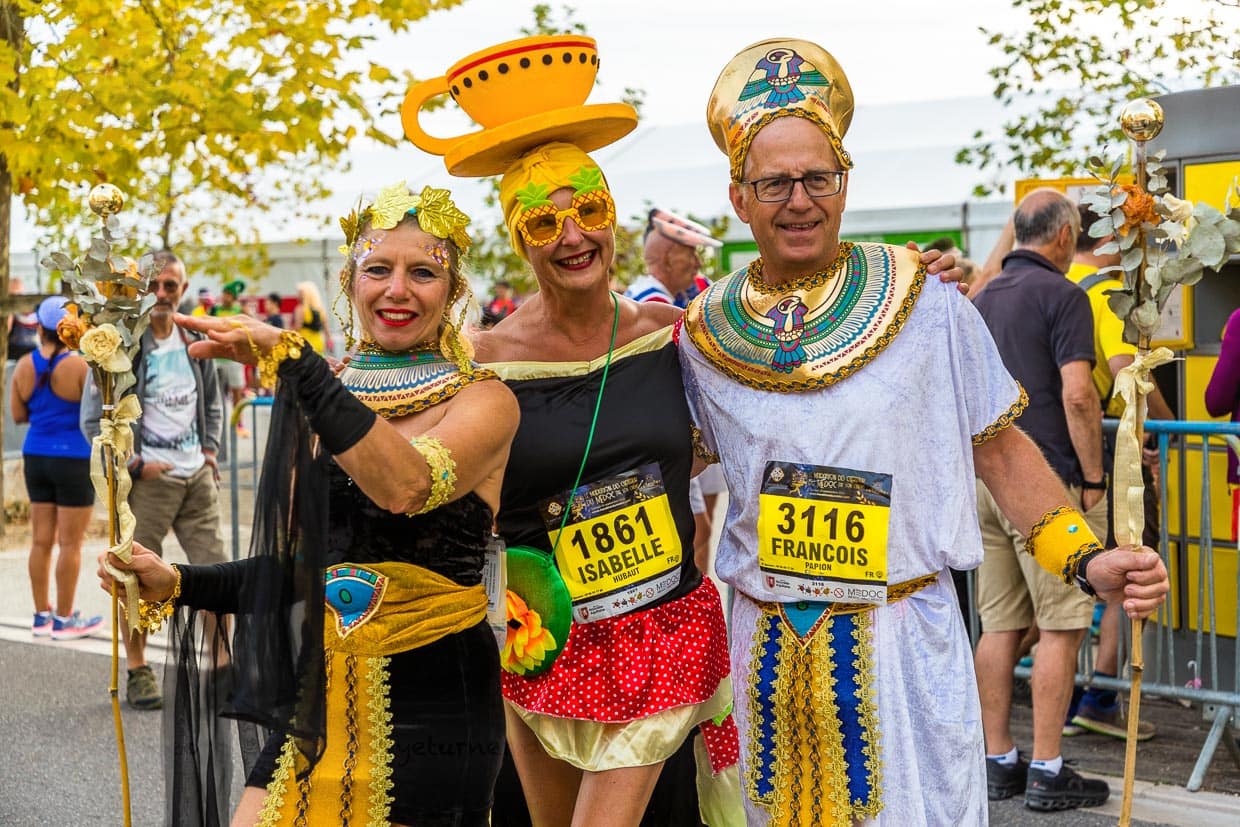 Vor dem Start des Marathon des Chateaux du Medoc gibt es das Defilee der Kostüme. Aus Lautsprechern schallt berühmte Filmmusik und auf der Straße am Ufer der Gironde trifft ein ägyptisches Herrscherpaar auf eine gut gelaunte Teetasse / © Foto: Georg Berg