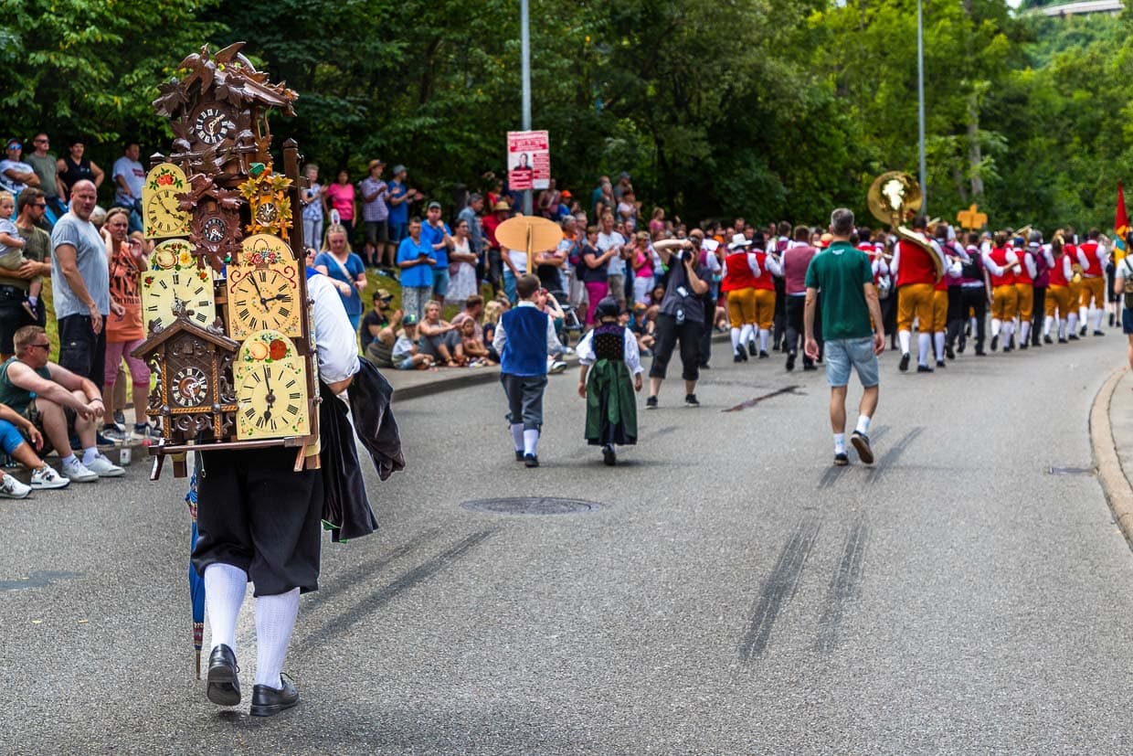Die Tradition der **Kuckucksuhrenträger** stammt aus dem Schwarzwald und geht auf die Zeit zurück, als die berühmten Schwarzwälder Uhren – darunter die Kuckucksuhr – von sogenannten Uhrenträgern auf dem Rücken über weite Strecken transportiert und verkauft wurden. Diese Uhrenträger nutzten eine spezielle Rückentrage, die „Krätze“, um die empfindlichen Uhren sicher zu Märkten und Kunden zu bringen / © Foto: Georg Berg