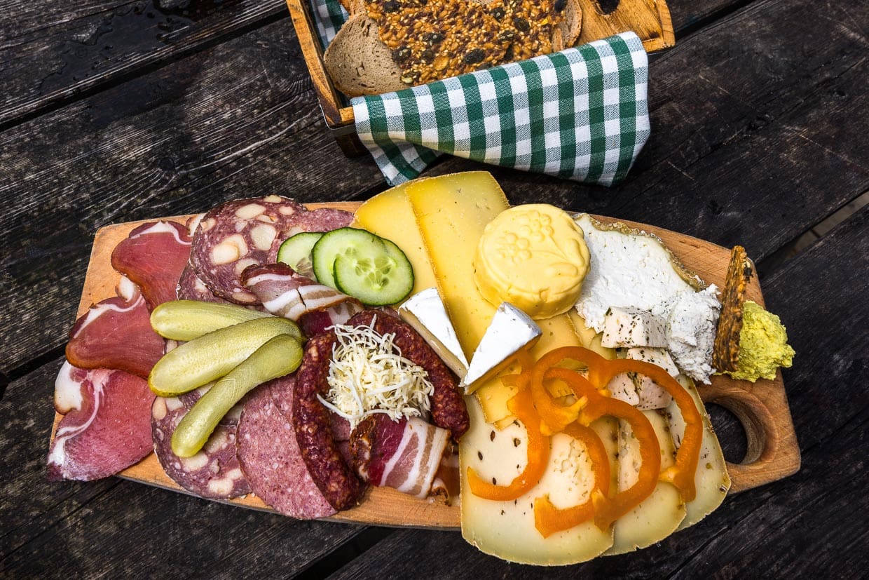 Jausenplatte auf der Filzmoosalm. Sauerkäse, Camenbert, Butter, Schnittkäse, Speck, Schinken und Wurst mit Brot stammen aus eigener Herstellung / © Foto: Georg Berg