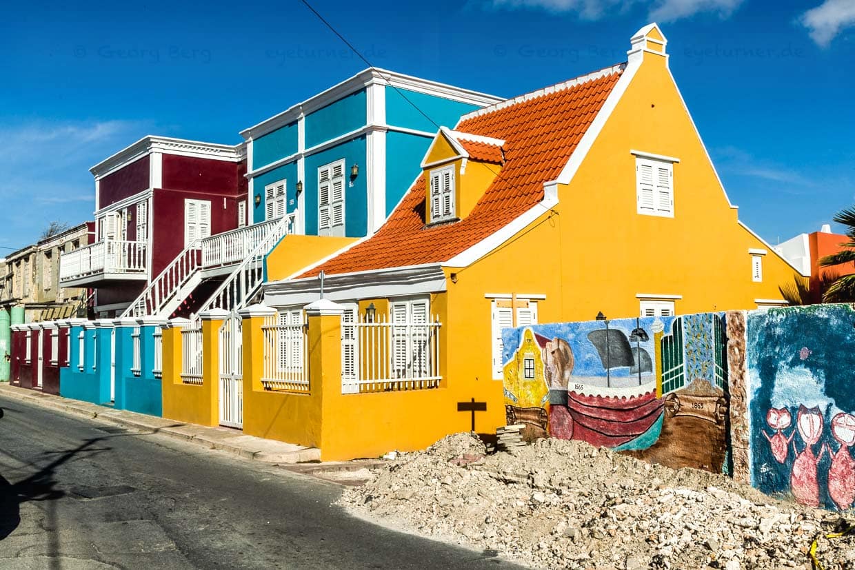 Ein Motiv aus der Sklavenvergangenheit der ehemals niederländischen Kolonie Curaçao. Freiheit und Transformation ist der Titel des Wandgemäldes auf einer Mauer neben den farbigen Wohnhäusern auf der Pietermaai Straße / © Foto: Georg Berg