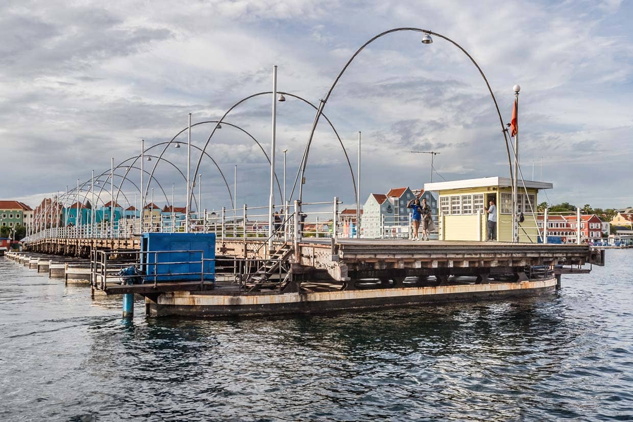 Der Bückenwärter öffnet und schließt die Königin Emma-Brücke mit einem starken Außenbordmotor. Passanten können auf der Brücke bleiben, während sie für Schiffe geöffnet wird / © Foto: Georg Berg