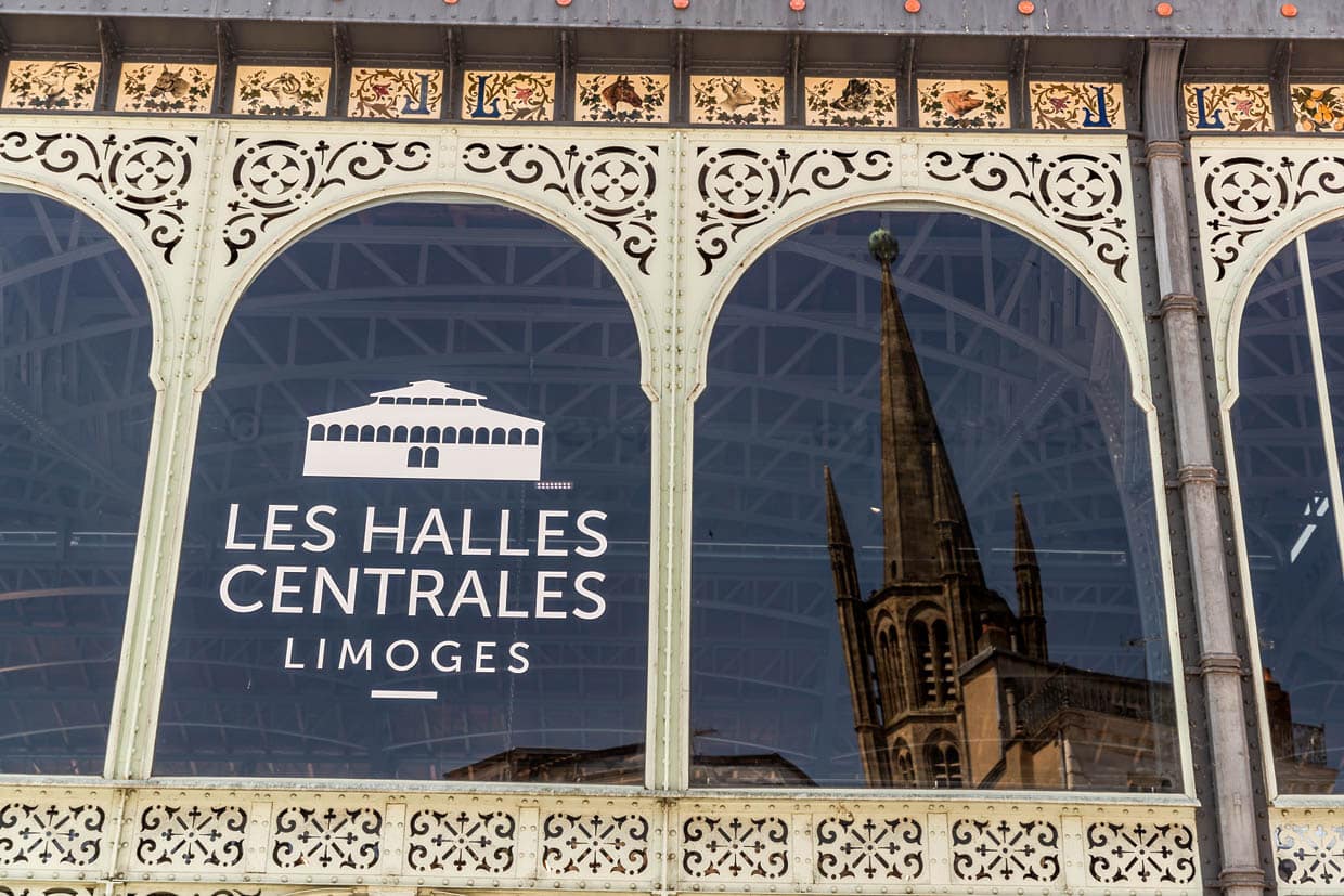 Fenster der Markthalle von Limoges mit Spiegelung der Kathedrale. Die Markthalle von Limoges, die sogenannten Halles centrales steht seit 1976 als Monument historique unter Denkmalschutz und beeindruckt besonders durch ein rundumlaufendes Porzellanfries mit 368 Kacheln, das Blumen, Vögel und Markthallenprodukte darstellt / © Foto: Georg Berg