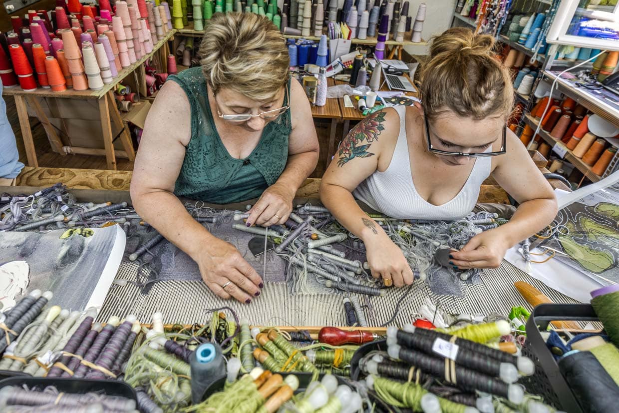 Zwei Weberinnen der Weberei Robert Four aus Aubussson umgeben von Wollgarnen und Webschiffchen in vielen Farbnuancen für den Wandteppich "Hommage à George Sand“ der französischen Künstlerin Françoise Petrovitch / © Foto: Georg Berg