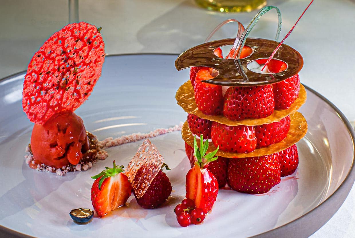 Dessert aus Mara des Bois Erdbeeren. Ein dreigeschossiges Erdbeerdessert mit Etagenböden aus Krokant-Chips und einem Erdbeer-Sorbet auf Rhabarber-Vervene-Mousse verziert mit einem Erdbeer-Algen Chipsmag man gar nicht mit seinem Löffel unterwandern, so schön ist es anzusehen / © Foto: Georg Berg