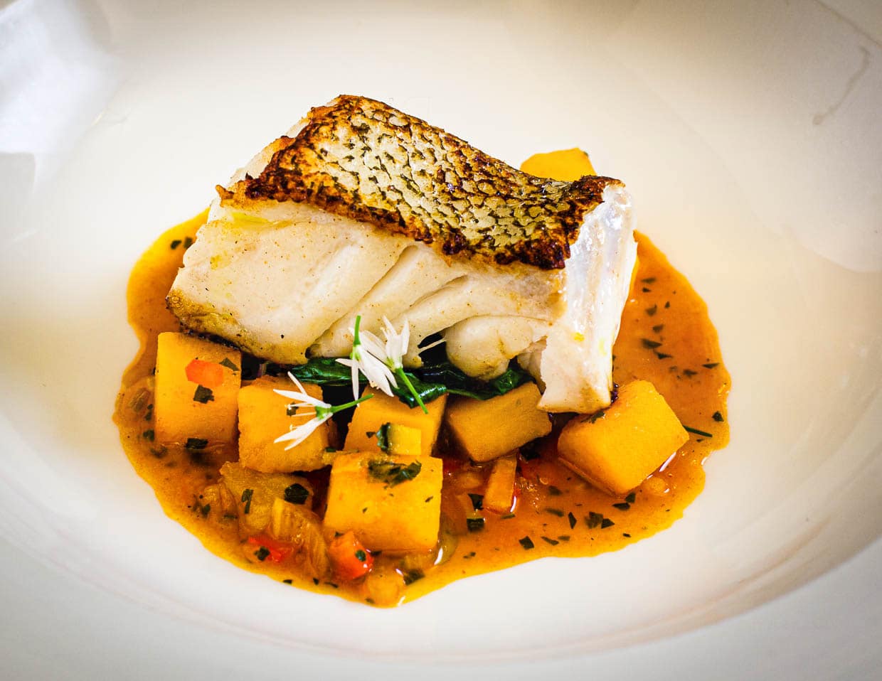 Cornish Cod. Kabeljau aus Cornwall mit Safran-Kartoffeln, Bouillabaisse, Spinat und Bärlauch / © Foto: Georg Berg