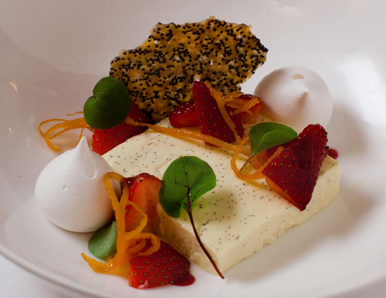Vanille-Panacotta mit Grappa, Erdbeeren und Baiser. Die Panacotta hat ein sehr intensives Vanille-Aroma. Orangenzesten sorgen für eine leichte und angenehme Bitternote und im Knusperchips sorgt Mohn für den richtigen Crunch / © Foto: Georg Berg