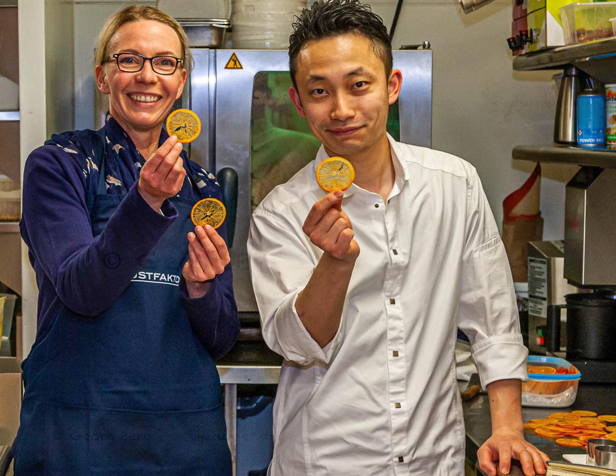 Journalistin Angela Berg mit Souchef Kazunori Tanigawa der seine hauchdünnen Orangencracker präsentiert / © Foto: Georg Berg