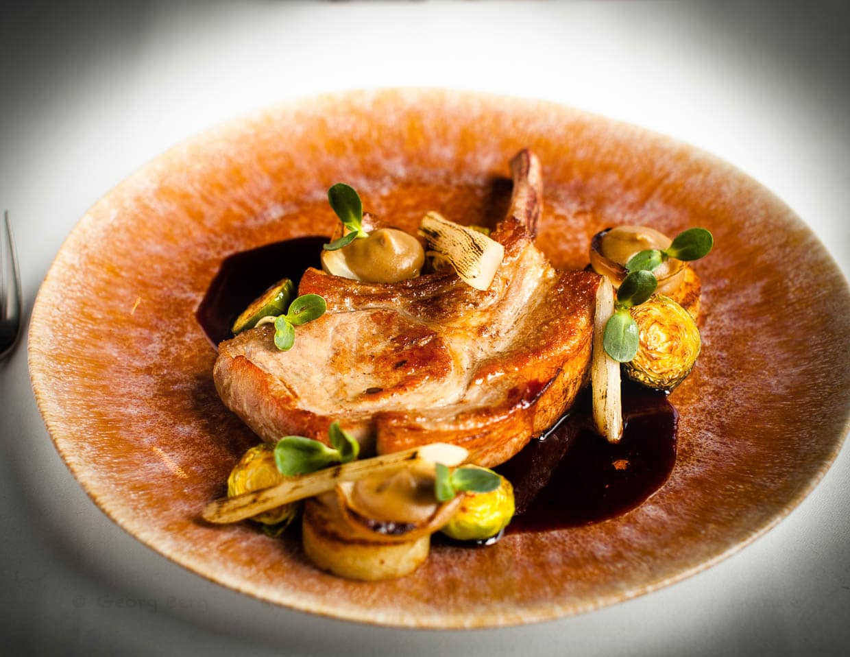 Kotelett vom Zlotnieka Schwein, einer 200 Jahre alten Schweinerasse mit Zwiebelpüree und Schwarzwurzel / © Foto: Georg Berg