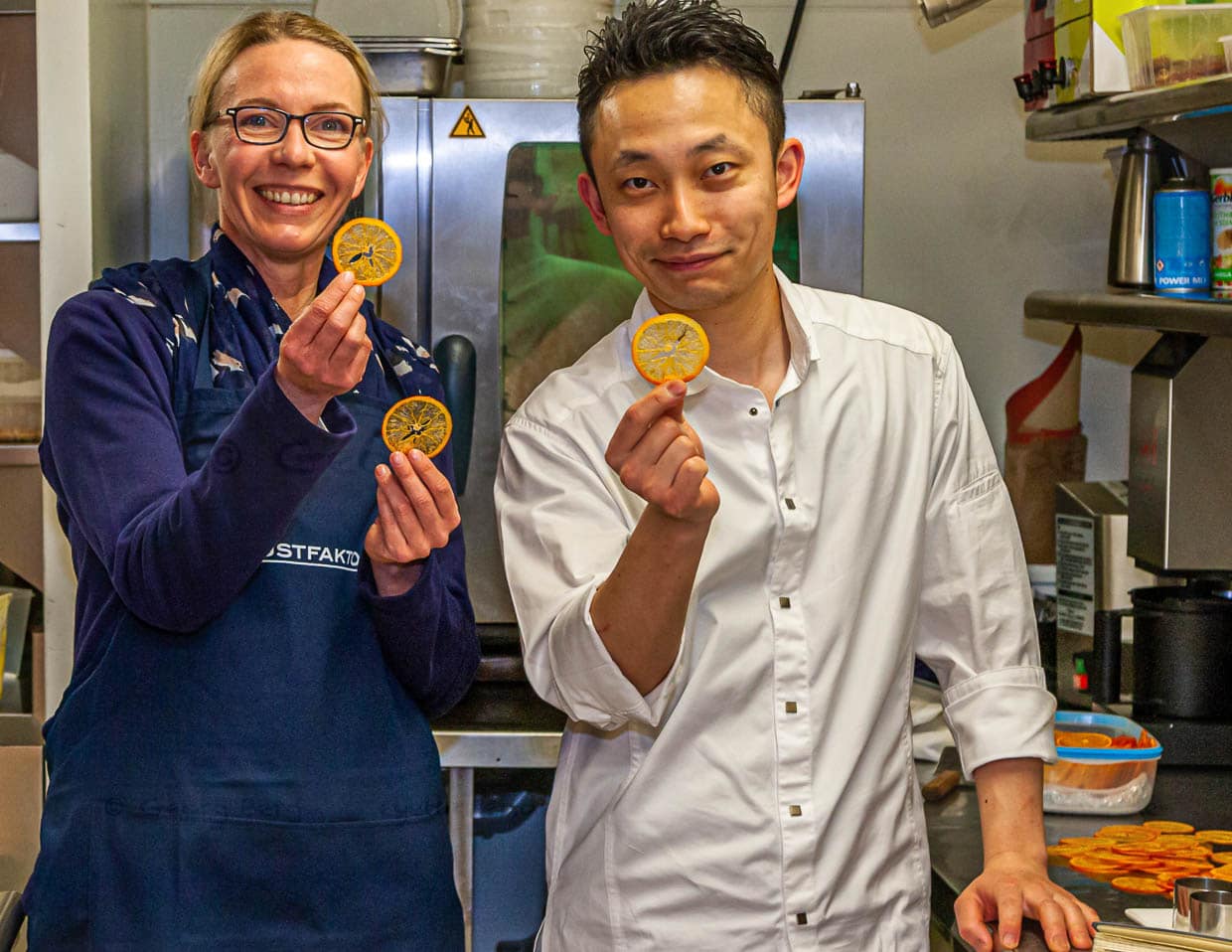 Journalistin Angela Berg mit Souchef Kazunori Tanigawa der seine hauchdünnen Orangencracker präsentiert / © Foto: Georg Berg